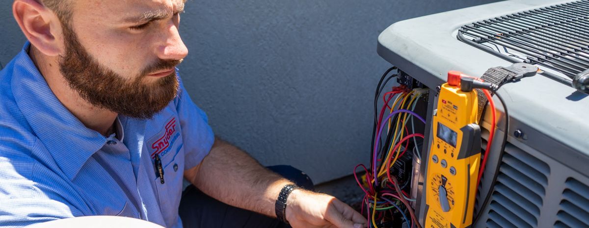 hvac tech checking ac unit