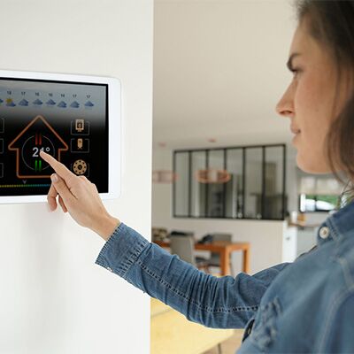 woman using smart thermostat