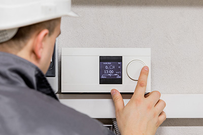 hvac technician inspecting thermostat