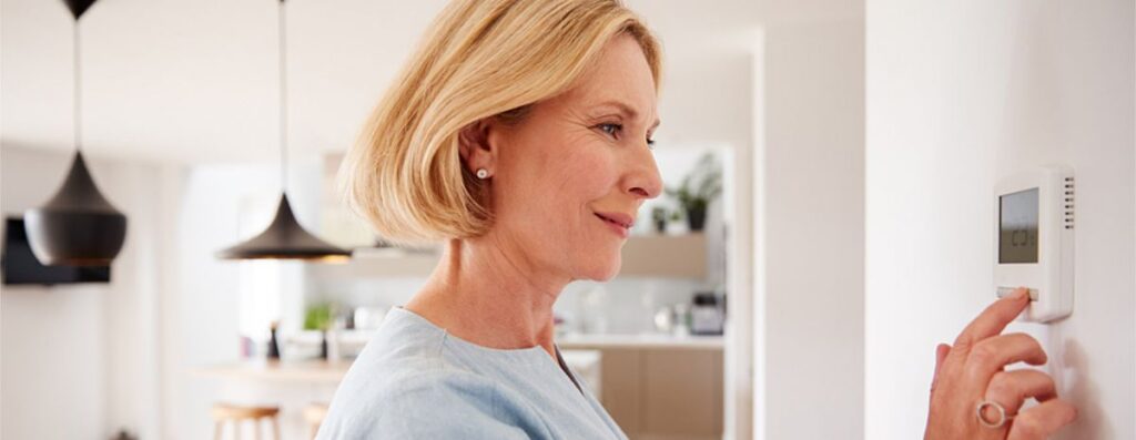 woman using thermostat